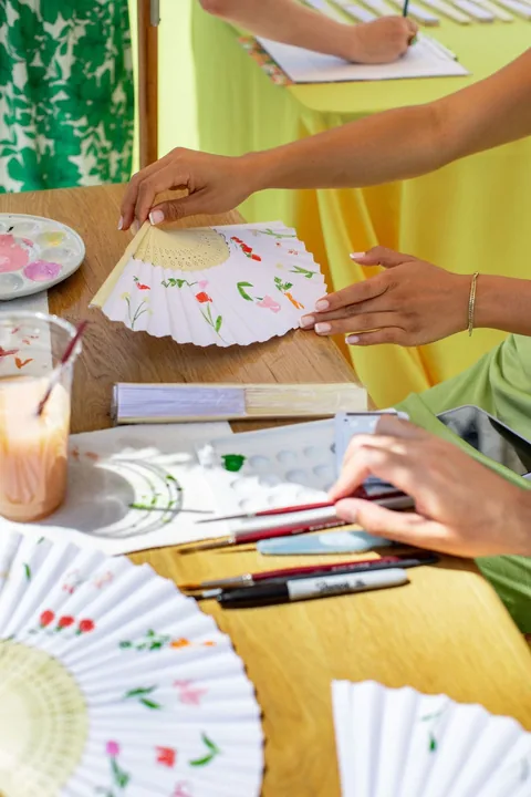 Mains en train de peindre des éventails pendant un atelier créatif